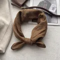 Dettaglio di un foulard quadrato in cotone marrone con bordi in pizzo all'uncinetto - Caramello