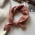 Dettaglio del foulard in cotone rosa polvere con pizzo all'uncinetto su lana beige - Rosa Coreano