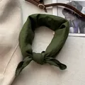 Primo piano dell'foulard in cotone verde scuro con bordi in pizzo all'uncinetto e nodo alla moda - Verde Primavera