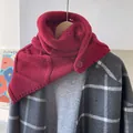 Nahaufnahme des roten grob gestrickten Wollkapuzenschals mit Knopf auf grauem Mantel - Rot