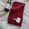 Detailed knit texture of a 100% wool dark red scarf with a ribbed edge on white fabric - Wine Red