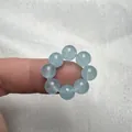 Primo piano dell'anello di perle di acquamarina blu naturale indossato sul dito - Calcedonio Blu