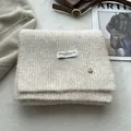 Macro shot of knit wool scarf texture with fashion label and thick ribbed pattern - Melange Beige