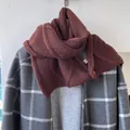 Écharpe en laine bordeaux à tricot torsadé portée sur un manteau à carreaux gris - Café