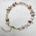 Detail van zoetwaterparel armband met rode kristalstenen en goudkleurige karabijnsluiting - Hematoïde kwarts