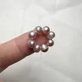 Dettaglio macro di perle d'acqua dolce viola chiaro naturale infilate in un anello fine - Perla Viola