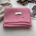 Detail of pink wool knit scarf with soft fluffy texture and premium metallic brand tag - Korean Pink