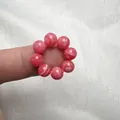 Macro di un anello in perle di agata rosa naturale con venature bianche al dito - Rodocrosite d'Imitazione