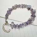 Detailed close-up of amethyst chips and floral charms on a beaded quartz bracelet - Lavender