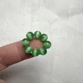 Dettaglio dell'anello con perle di occhio di gatto verde con effetto gatteggiamento - Occhio di gatto verde