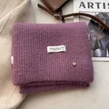 Close-up of purple wool knit scarf featuring thick ribbed texture and woven label detail - Bean Paste Purple