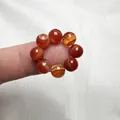 Vista dettagliata di perle in agata rossa con trama naturale a strisce sulla mano - Agata Naturale