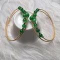 Close-up of 14K gold filled bangles with green cat eye stones and small white pearls - Green Cat's Eye Style