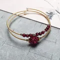 Macro shot of 14K gold filled garnet bracelet with woven beads and pearl details - Garnet Style