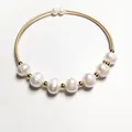 Detailed close-up of 14K gold wire bracelet with seven natural white freshwater pearls - White Pearl