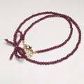 Elegant garnet beaded necklace featuring golden bow accent and adjustable clasp closure - Necklace Style