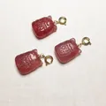 Trois pendentifs en cristal fraise rouge avec fermoirs mousquetons dorés sur lin - Forme de sac de fortune