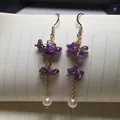 Détail de boucles d'oreilles pendantes avec pierres améthyste et perles blanches - Style Améthyste