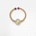 Detailed view of handmade 14K gold wire wrapped ring with rutilated quartz and garnet beads - Rutilated Quartz