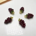 Detailed view of five handcrafted garnet grape pendants with green leaves and gold stems - Purple (Green Leaf Gold Clasp)