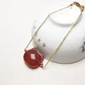 Detailed shot of a gold strawberry quartz bracelet featuring a carved cat head pendant - 14K Gold Filled Thin Chain Style
