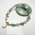 Detailed close-up of baroque pearls with green crystal stones and gold clasp on a bracelet - Apatite and Baroque Freshwater Pearl
