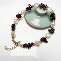 Close-up of Baroque freshwater pearl bracelet with red garnet stone and golden clasp - Garnet and Baroque Freshwater Pearl