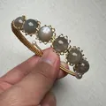 Detail of 14K gold wire wrapped sunstone bracelet with small white pearls - 6 Gray Beads Wave Wrapped Style (Style 5)