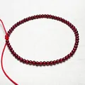 Macro shot of 4mm garnet beads with cat-eye effect on adjustable red cord - Bracelet 2.8MM Diameter 16CM Length