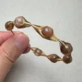 Detailansicht des handgefertigten Sonnenstein-Armbands mit 14K Golddrahtumwicklung - Rotbrauner Runder Perlenstil (Stil 2)
