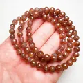 Makroaufnahme von Super Seven Naturkristall-Armband mit rötlichen Mineraleinschlüssen - Auralite 23 Gebetsperlen