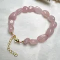 Detalle de pulsera de cuentas de cuarzo rosa con cierre de langosta dorado y cadena - Pulsera de Cuarzo Rosa