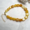 Dettaglio di un bracciale con perle di pietre naturali gialle con chiusura a moschettone dorata - Braccialetto di Giada Gialla
