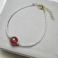 Detail of beaded strawberry quartz bracelet with white spinel and golden clasp extension - Bracelet Style