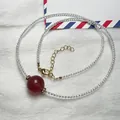 Close-up of strawberry crystal bead necklace with faceted white spinel and gold lobster clasp - Necklace Style