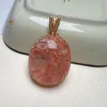 Detailed macro view of handmade gold wire-wrapped oval snowflake phantom quartz pendant - Oval Orange Ruby Style (No. 2, 27.9g, 52*32mm)