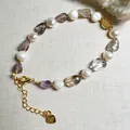 Detailaufnahme von Barockperlen und Amethyststeinen auf vergoldetem Armband mit 925er Stempel - Super Seven mit Süßwasserperle