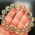 Primer plano de pulsera de cuarzo fantasma verde natural con cuentas de cristal en una mano - Estilo 4
