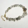 Detailed macro view of natural gemstone beads bracelet with gold-plated lobster clasp - Green Rutilated Quartz