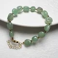 Detailansicht grünes Kristallarmband mit goldenen Zwischenperlen und Karabinerverschluss - Aventurin-Jade