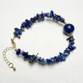 Macro shot of natural lapis lazuli stone bracelet with golden lobster clasp and chain - Lapis Lazuli