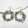 Dettaglio di orecchini dorati con cerchi di pietre di labradorite naturale irregolare - Labradorite
