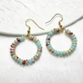 Dettaglio di orecchini boho dorati con perle di quarzo e granato naturale irregolare - Pietra Shoushan