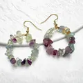 Dettaglio ravvicinato di orecchini a cerchio con cristalli naturali misti e ganci dorati - Fluorite