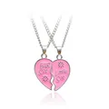 Detail view of pink heart-shaped pendant necklaces with Big Sis and Little Sis engravings - Pink
