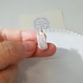 Detalle macro de un colgante de perla barroca con envoltura de alambre de plata hecho a mano - Colgante de perla cuadrada