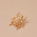 Detailopname van een matgouden keverbroche met fijn gegraveerde dubbele bloemblaadjes - Gouden Chrysanten Kever Brosche