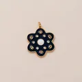 Detailed close-up of a vintage black enamel flower keychain with gold-plated petals - Deep Blue Flower Style
