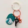 Close-up of a spiral wristband with an orange whistle and polar bear bag charm accessory - Hippo Whistle Charm