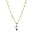 Detailed shot of gold necklace with a white pearl and vibrant red zircon pendant charm - January Necklace